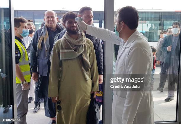 Medical officer scans a passenger for signs of fever at a bus station as a precaution against the coronavirus in Kabul, Afghanistan on March 27, 2020.