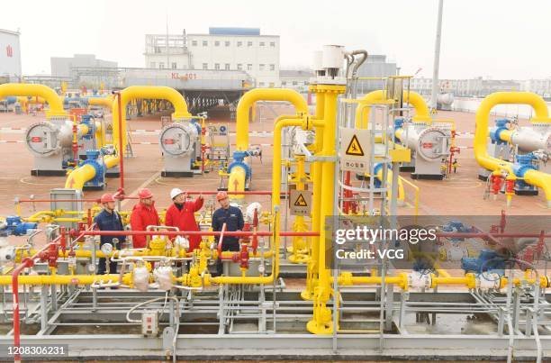 Workers inspect gas pipes at a natural gas transfer facility operated by China National Petroleum Corporation on January 19, 2020 in Dingyuan County,...