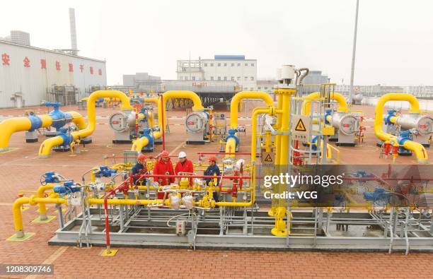 Workers inspect gas pipes at a natural gas transfer facility operated by China National Petroleum Corporation on January 19, 2020 in Dingyuan County,...