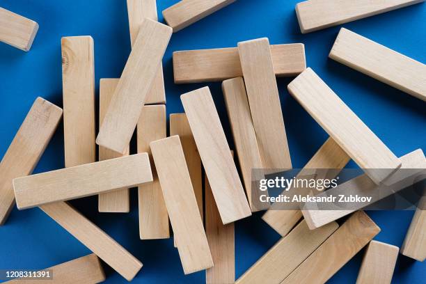 a pile of scattered wooden blocks on a blue background. construction game. the broken tower. - block removal game stock pictures, royalty-free photos & images