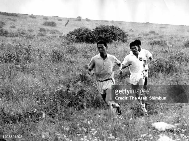 Kenji Kimihara and Eiji Tsuburaya run during the Japan marathon team training at Kirigamine Highland on July 28, 1964 in Suwa, Nagano, Japan.