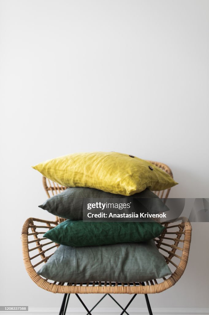 Set Of Folded Green and Yellow Pillows On A Armchair.