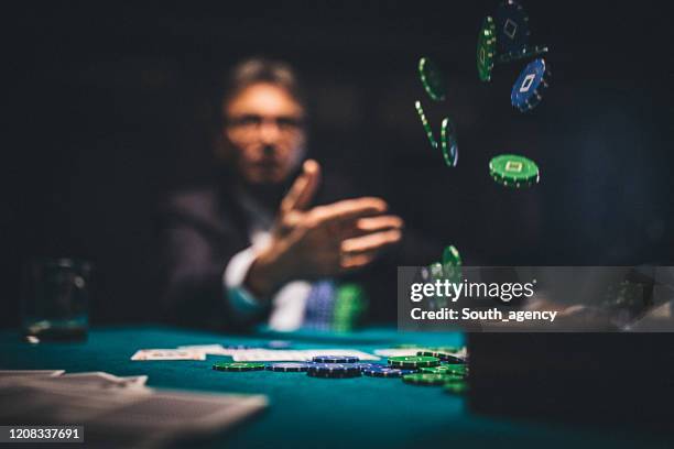 senior mann wirft glücksspiel chips auf den tisch - werfen stock-fotos und bilder