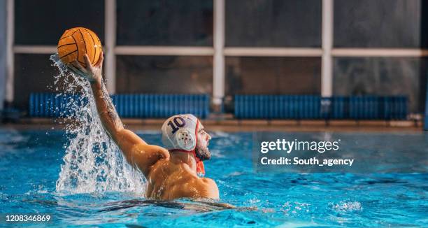jonge mens die waterpolo speelt - waterpolo stockfoto's en -beelden