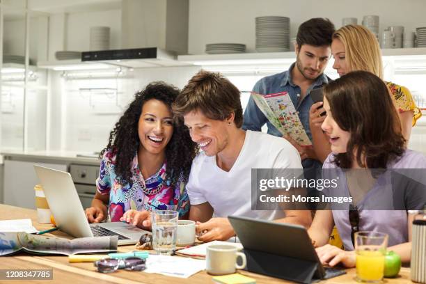 amici che pianificano il viaggio su laptop a colazione - five people foto e immagini stock