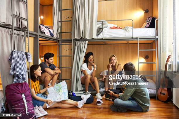 young friends planning trip in hostel - hostel stock pictures, royalty-free photos & images