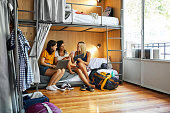 Friends planning trip on bunkbed in dorm room