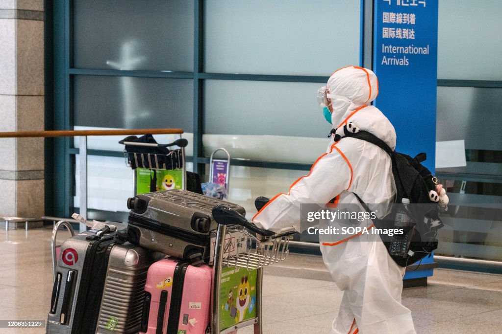 A passenger wearing a protective suit seen at the arrival...