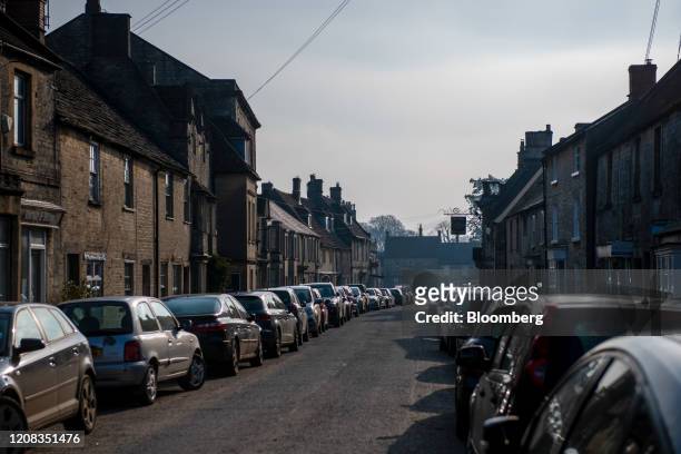 Parked cars line the high street in Marshfield, U.K., on Friday, March 27, 2020. U.K. Prime Minister Boris Johnson announced sweeping restrictions on...