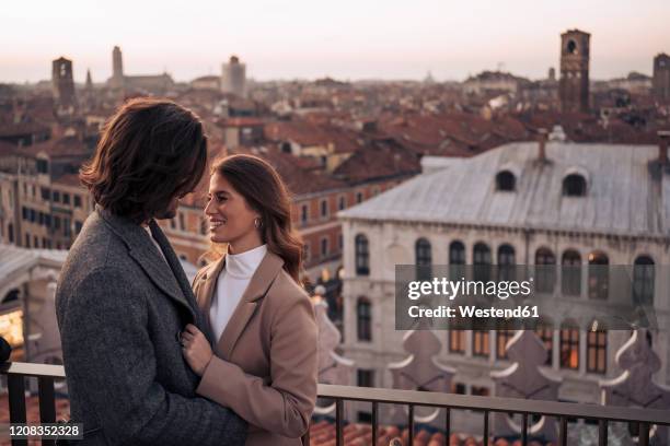 happy young couple on a balcony above the city of venice, italy - venice with couple stock pictures, royalty-free photos & images