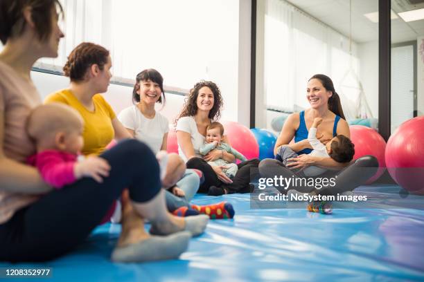 moeders en baby's op oefeningsklasse met een instructeur - baby group stockfoto's en -beelden