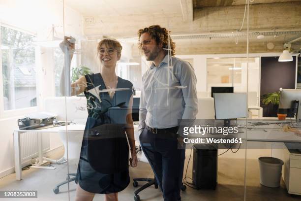 businessman and businesswoman working on a project in office - engineers brainstorming stock pictures, royalty-free photos & images