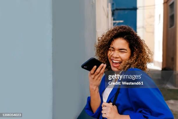 portrait of happy brazilian woman sending an voice message - irony stockfoto's en -beelden