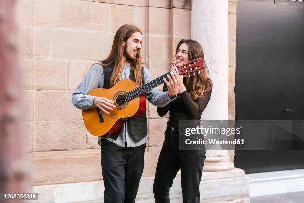 portrait of two happy young musicians in the city - tanzpaar stock-fotos und bilder