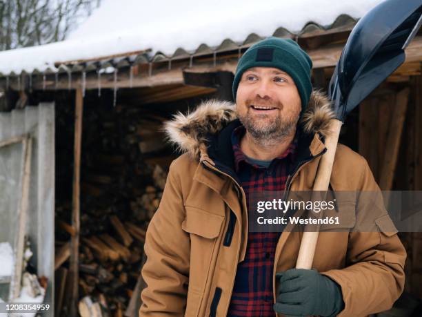 portrait of smiling man with snow shovel - snow shovel man stock pictures, royalty-free photos & images