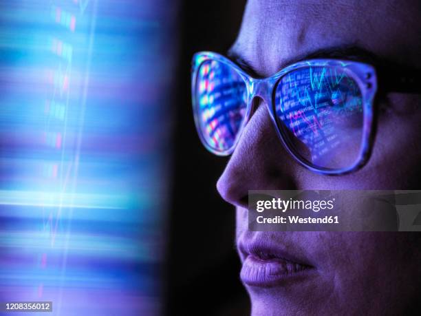 female analyst viewing financial market data on a screen - looking down photos et images de collection