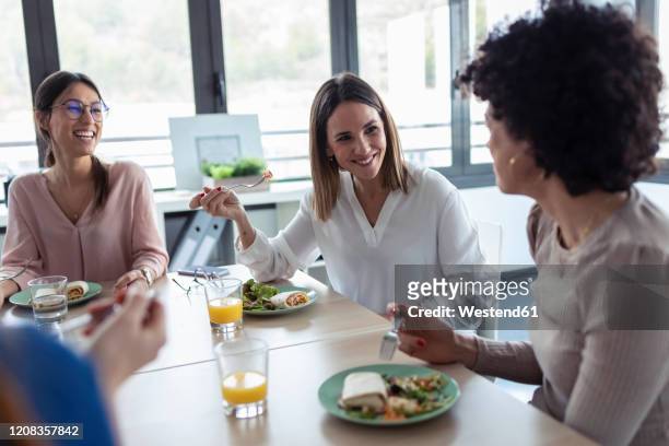 businesswomen during lunch in an office - lunch lady foto e immagini stock