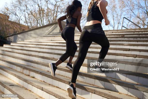 two sportswomen during workout on stairs - leggings fotografías e imágenes de stock