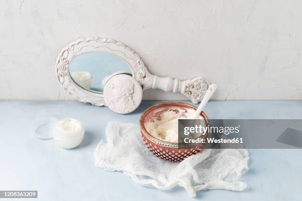 gauze, hand mirror and bowl of homemade shea butter moisturizer - shea butter stock pictures, royalty-free photos & images