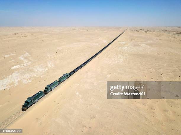 mauritania, nouadibou, aerial view of cargo train riding through desert - mauritania stock pictures, royalty-free photos & images