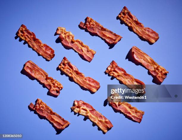 studio shot ofbacon strips against purple background - spek stock-fotos und bilder