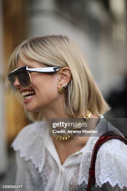 Xenia Adonts is seen wearing a Etro bag, Louis Vuitton shades and Mugler red pants before Etro during Milan Fashion Week Fall/Winter 2020-2021 on...