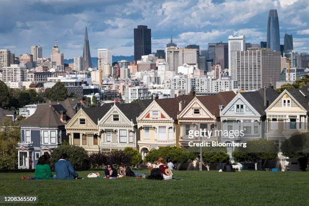 People sit in Alamo Square overlooking the city skyline in San Francisco, California, U.S., on Thursday, March 26, 2020. Governor Newsom on March 19...