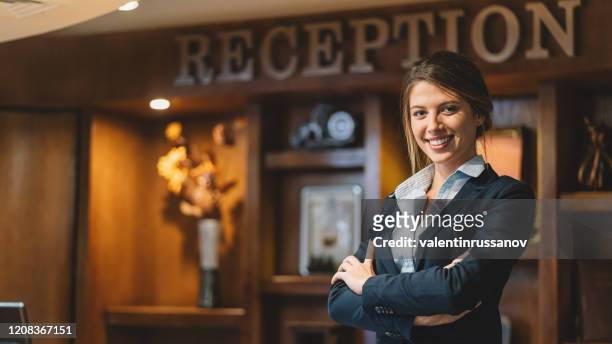 réceptionniste confiant avec les bras croisés à la réception d’hôtel - reception hotel photos et images de collection