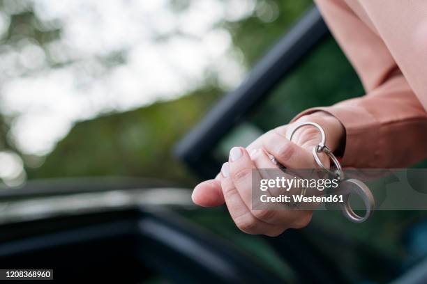 woman's hand holding car key, close-up - car keys hand ストックフォトと画像
