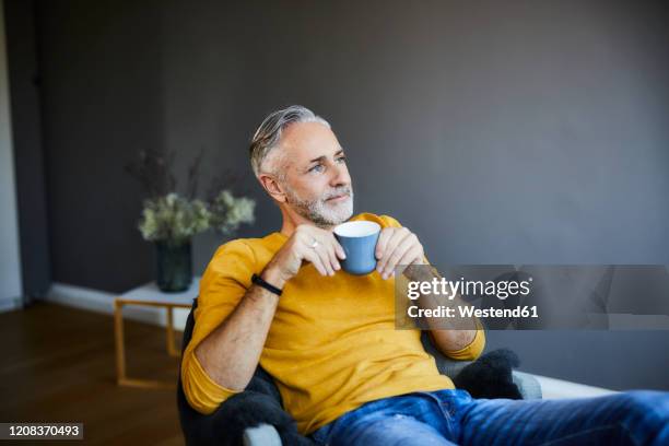 relaxed mature man at home with cup of coffee - gente tranquila fotografías e imágenes de stock