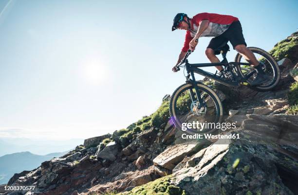 mountainbiker mountain biking against the sun in grisons, switzerland - lenzerheide stock pictures, royalty-free photos & images