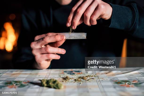 close-up of a man's hands preparing marihuana joint - rolling stock-fotos und bilder