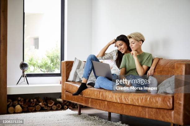 女同性戀夫婦在家裡看筆記本電腦看電影 - lesbian dating 個照片及圖片檔