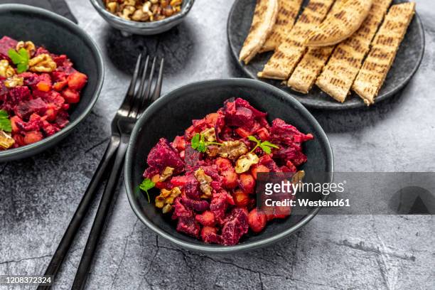 pita bread and plates of beetroot salad with chick-peas, roasted walnuts and parsley - chick pea salad stock pictures, royalty-free photos & images