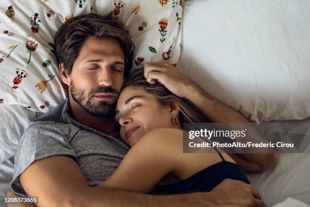 couple sleeping on bed - paar kuscheln bett stock-fotos und bilder