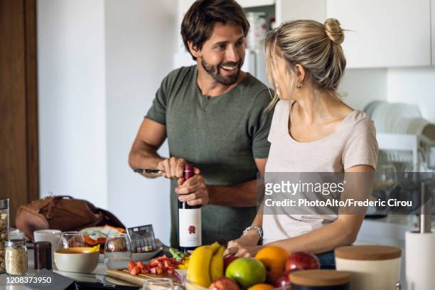 couple preparing food in kitchen - ehemann stock-fotos und bilder