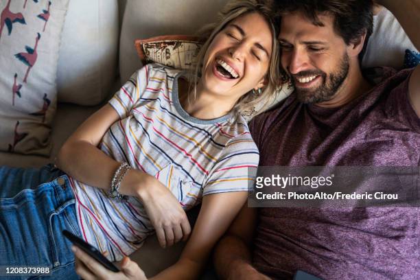 couple relaxing on sofa - lying on back photos 個照片及圖片檔