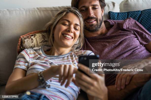 couple using smart phone - young couple stock-fotos und bilder