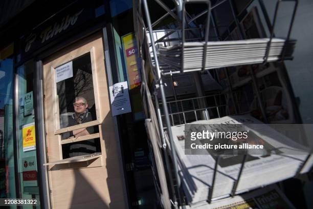 March 2020, Baden-Wuerttemberg, Stuttgart: Volker Suchanek, owner of the retail store Abele Tabakwaren, stands behind a protection of wood and...