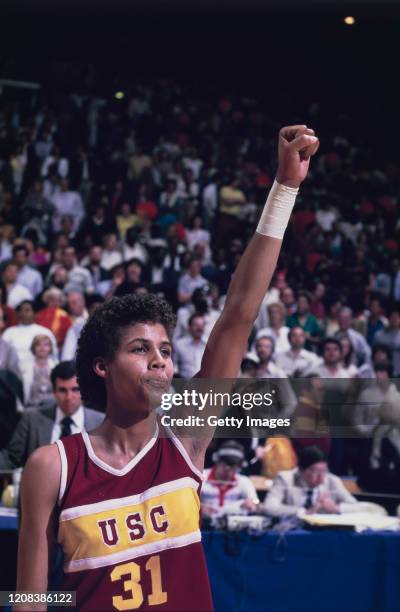 American basketball player Cheryl Miller of USC Trojans gives a clenched fist salute during an away game, circa 1983.