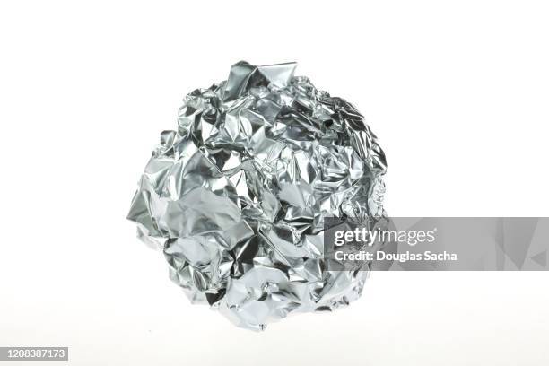 ball of aluminum foil on a white background - foil foto e immagini stock