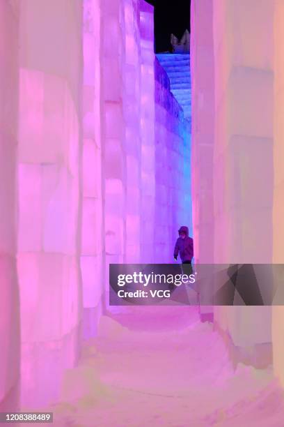 Child visits illuminated ice sculptures during the 36th Harbin International Ice and Snow Festival at the Harbin Ice and Snow World on December 31,...