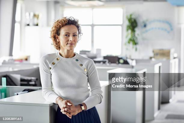 confident businesswoman with hands clasped - 50 54 years stock pictures, royalty-free photos & images