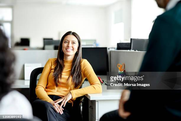 glimlachende onderneemster in vergadering met collega's - informeel zakelijk stockfoto's en -beelden
