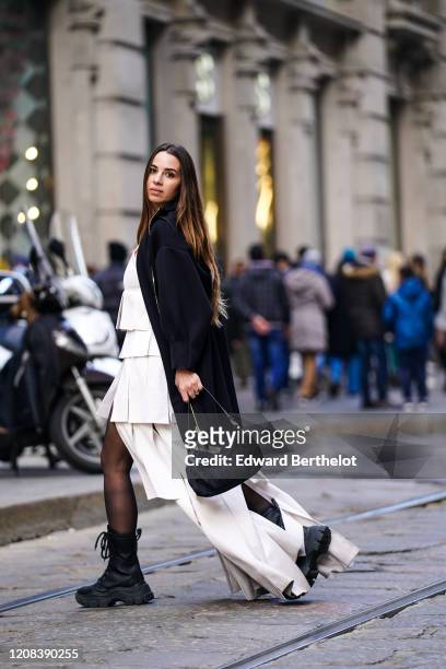 Maria Rosaria Rizzo wears a white top, a white long skirt, a Fendi bag, a dark long jacket, tights, boots, during Milan Fashion Week Fall/Winter...