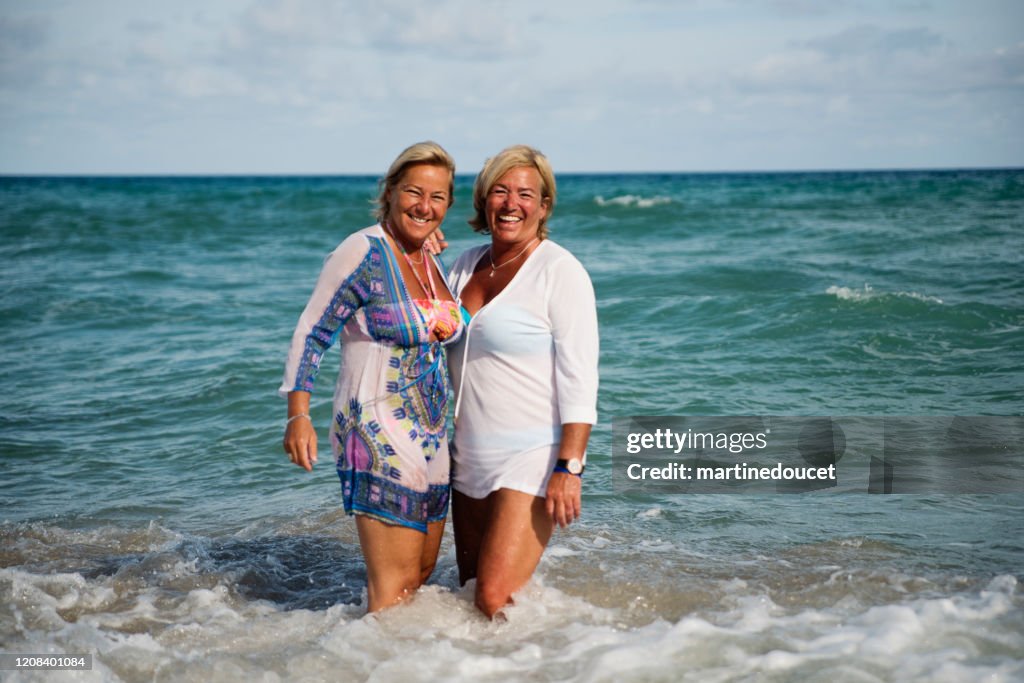 Un par de mujeres LGBTQ maduras posando en la playa.