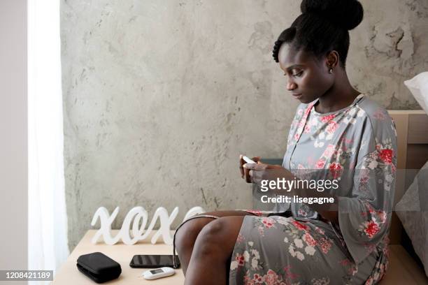 mujer africana tomando nivel de azúcar en la sangre en diferentes momentos del día - lancet arch fotografías e imágenes de stock