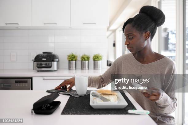 mujer africana tomando nivel de azúcar en la sangre en diferentes momentos del día - lancet arch fotografías e imágenes de stock