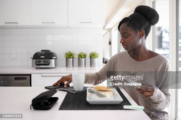 一日の異なる時間に血糖値を取るアフリカの女性 - ブドウ糖 ストックフォトと画像