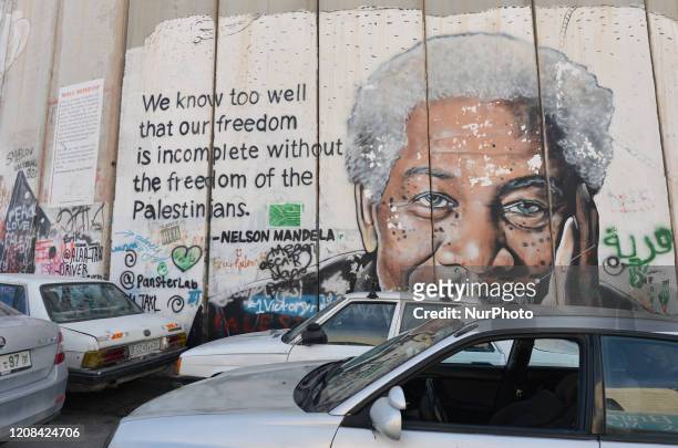 An image of actor Morgan Freeman accompanied by a quote by Nelson Mandela among other political and social mural paintings and graffitis on the wall...